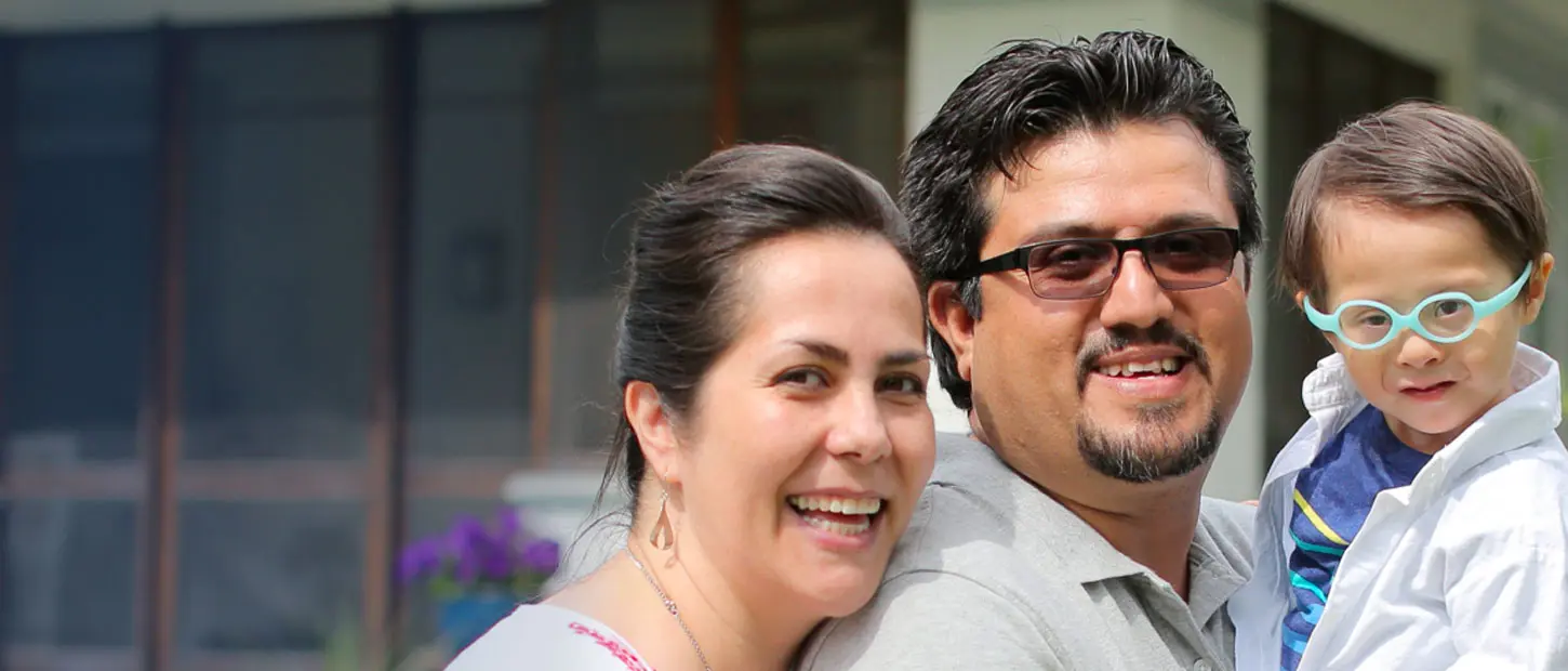 A couple smiles with their child